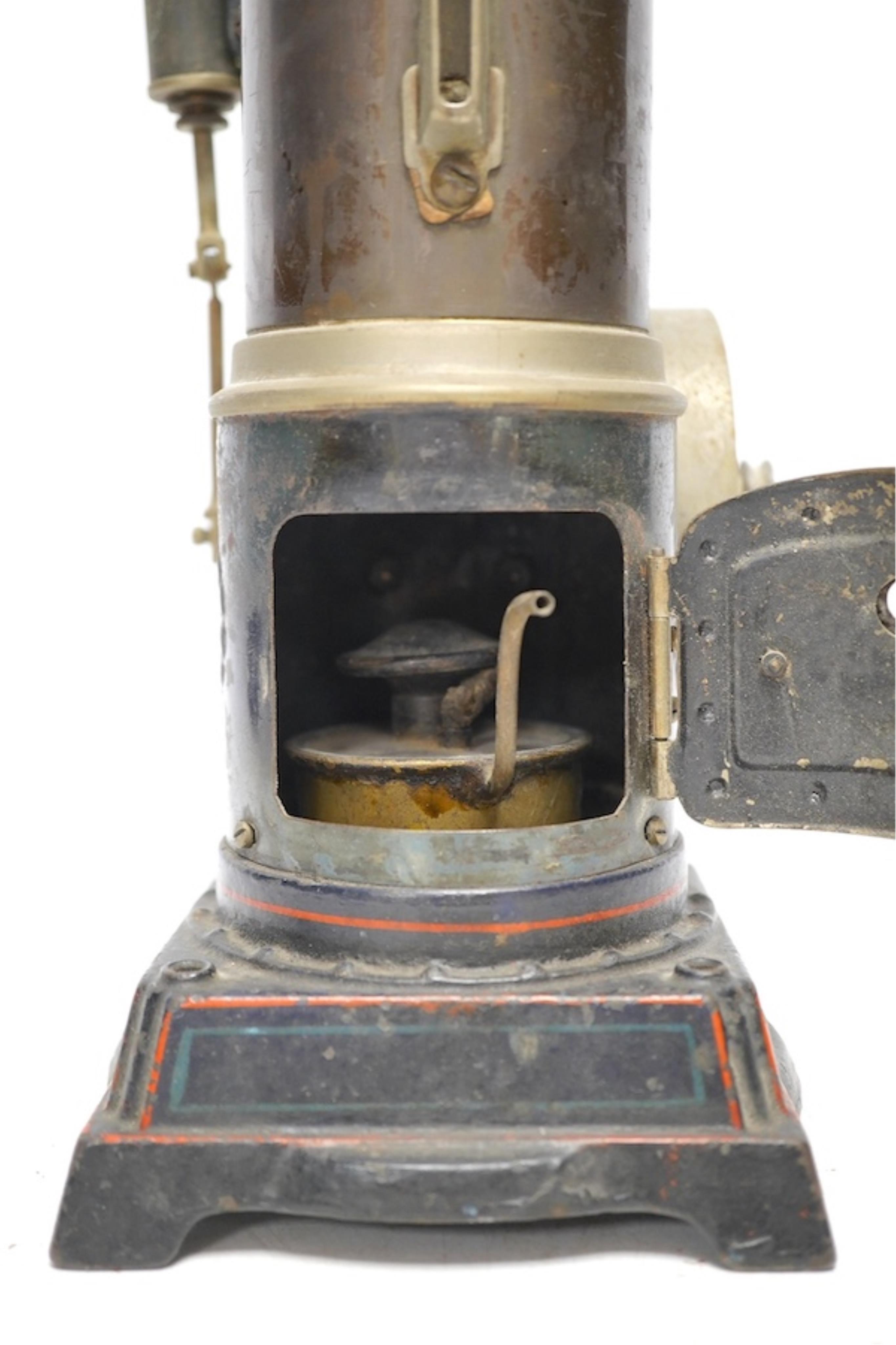 A Doll and Co. tinplate vertical boiler live steam single cylinder stationary engine, 26cm high. Condition - fair